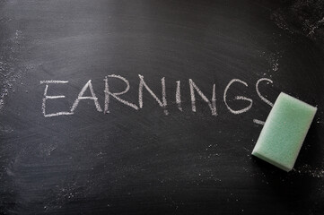 erasing earnings, hand written word on blackboard being erased concept