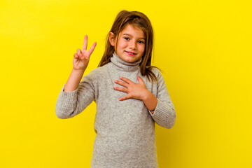 Little caucasian girl isolated on yellow background taking an oath, putting hand on chest.