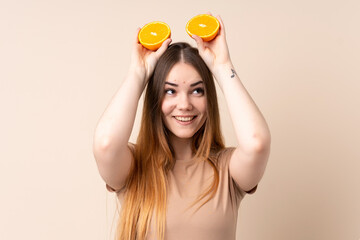 Obraz na płótnie Canvas Young caucasian woman holding an orange