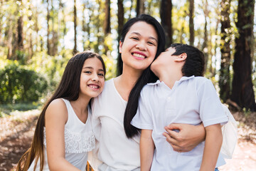 Obraz premium A happy mother enjoying her children in a park.