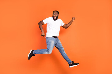 Fototapeta na wymiar Full size photo of brown haired dark skin young man jump up air sale dream isolated on orange color background