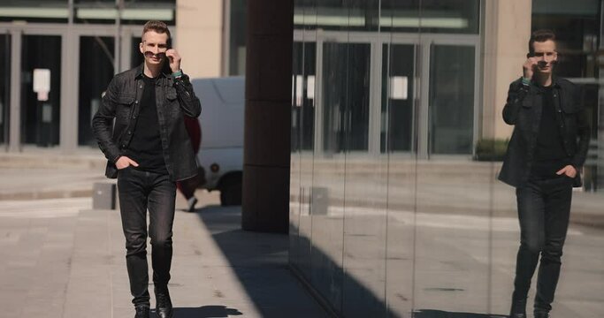 Stylish fashion man wearing sunglasses walking in a city, slow motion
