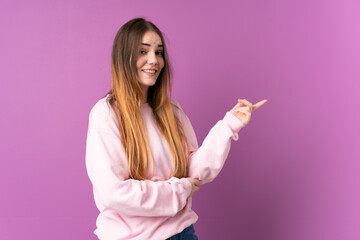 Young caucasian woman isolated on purple background pointing finger to the side