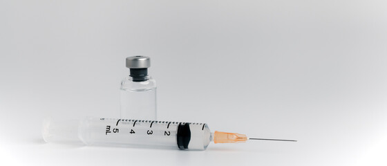 The vaccine vials, syringes and stethoscope are placed together on a white background. COVID-19...