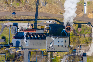 Aerial top view of an industrial building with smoke rising from the chimney