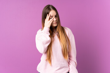 Young caucasian woman isolated on purple background with headache