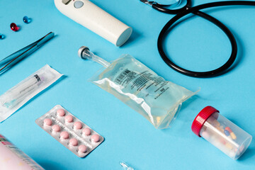 The close-up view of a medical instruments consisting of tweezers, syringe, pills, liquid container...