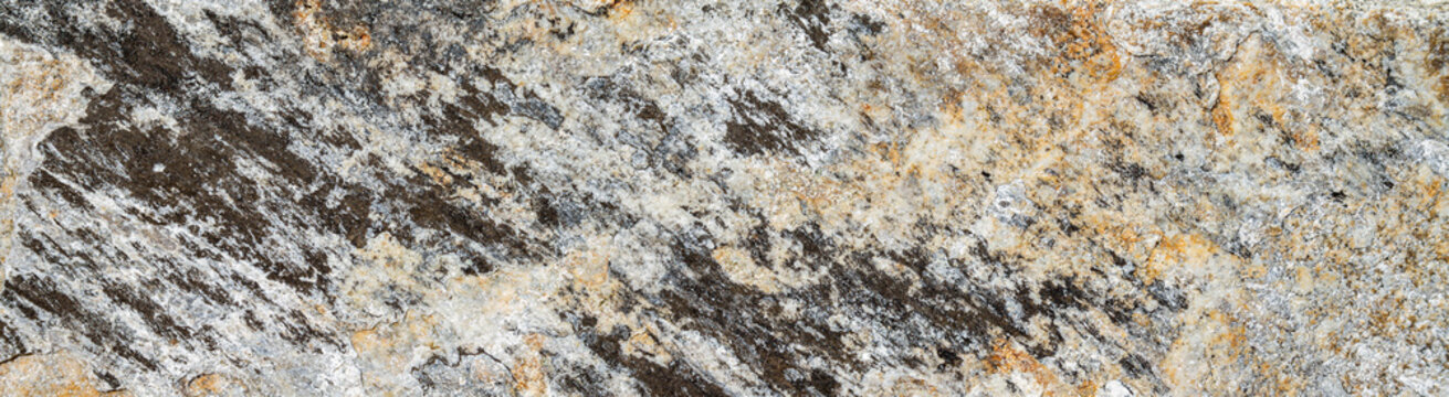 Wide natural stone wall texture. Grey granite and quartz stone surface background. 