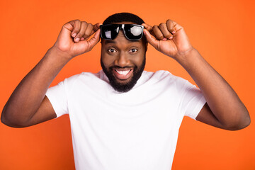 Photo of cheerful positive cool young afro american man wear sunglass good mood isolated on orange color background