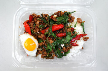 Food delivery in plastic box, Thai basil fried rice menu, street food of Thailand