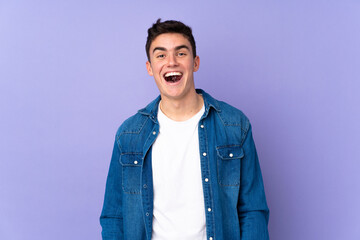 Teenager caucasian  handsome man isolated on purple background with surprise facial expression