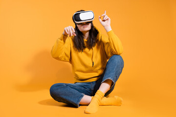 young woman with a virtual reality device on a yellow background.