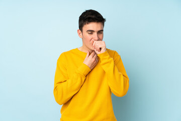 Teenager caucasian handsome man isolated on purple background is suffering with cough and feeling bad