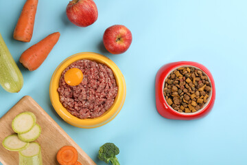 Pet food and natural ingredients on light blue background, flat lay
