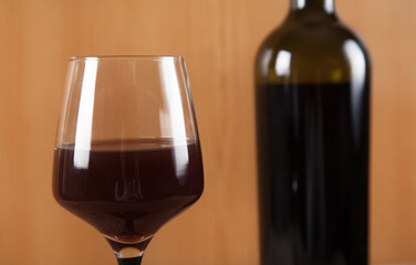 Bottle, glass and  wine on wooden background.