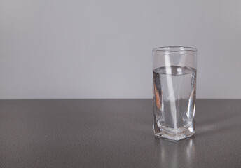 Water with glass, on gray background.