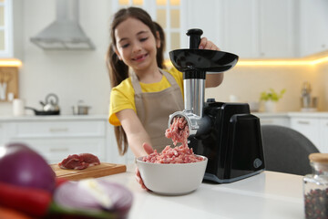 Little girl using modern meat grinder in kitchen