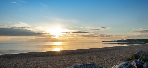 Sunset on Lake Onega. Beautiful landscape with reflection, blue sky and yellow sunlight in sunrise