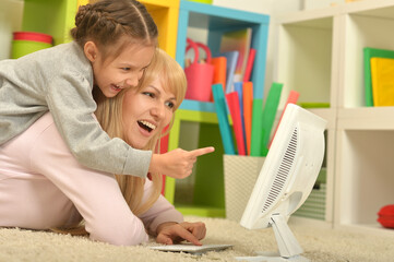 Portrait of mother and daughter using computer