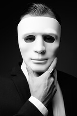 Young businessman against gray background in black and white