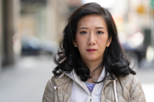 Asian woman serious face portrait on a city street