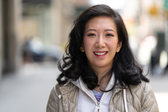 Asian woman smile happy face portrait on a city street