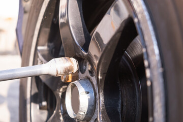 Car wheel replacement. Self-service tire fitting concept. Using a wheel wrench to twist the wheel nuts.