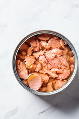 Close up of tin can of tuna fish, top view, white marble background. Canned food concept.