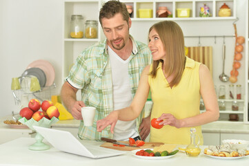 Happy husband and wife cooking together in the kitchen