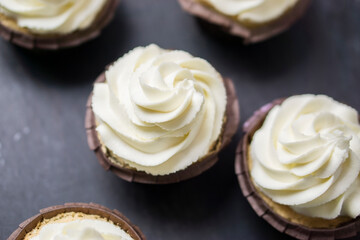 Top view  cupcakes  with white butter cream on dark background.