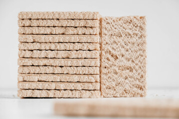 Stacked rye crisp bread on a white wooden background. Copy, empty space for text