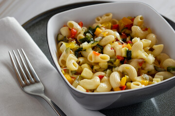Close up of pasta salad with vegetables in small bowl
