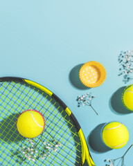 Tennis. Sunny summer sport composition with yellow tennis balls and racket on a blue background of...