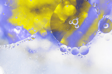 Oil bubbles close up. circles of water macro. abstract light blue and yellow background