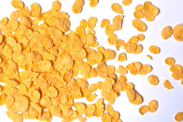 Cornflakes are scattered on a light background.