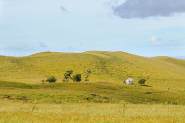 Lonely house at the top of a hill with some clods on the horizon at Terevaka volcano, Easter Island, Chile