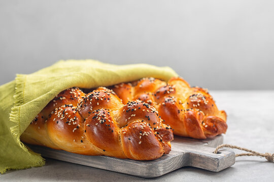 Two loaves of homemade Challah bread with green cover. Selective focus. Copy space.