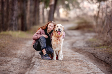 Girl with golden retriever dog in the wood