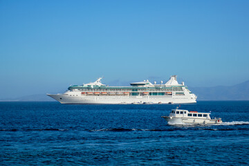 Fototapeta na wymiar Boat and cruise liner is Aegean sea. Chora, Mykonos island, Greece
