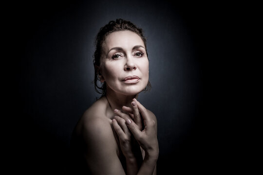 portrait of a sensual fifty year old woman on grey studio background