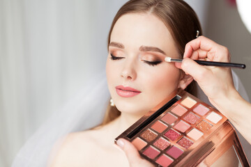 Wedding Make up Artist making Professional Bride Makeup. Bridal Eyeshadow Palette. Wedding Cosmetics Salon Face. Close up Beauty Bride Face Closed Eyes - 430163838