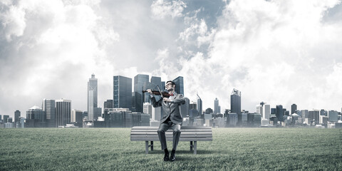 Handsome businessman in park on wooden bench play his melody