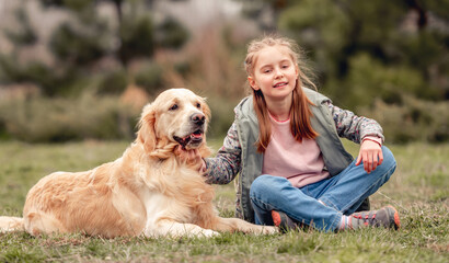 Little girl with golden retriever dog outside