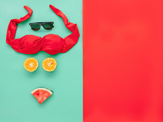 summer accessories concept from red bikini, sunglasses and tropical fruit on colorful background.