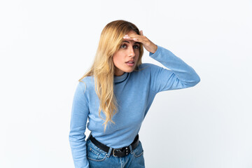 Young blonde Uruguayan woman over isolated background looking far away with hand to look something