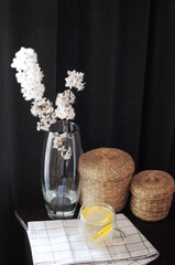 Composition of spring blossom flowers in vase on dark background with cup of tea