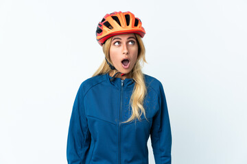 Young blonde Uruguayan cyclist woman isolated on background looking up and with surprised expression