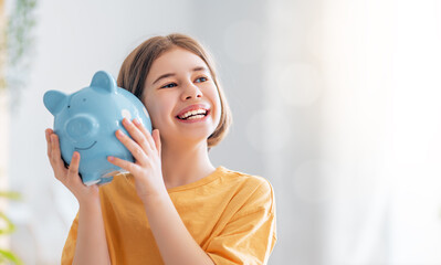 Happy girl with piggy bank.