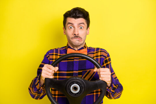 Photo of driver guy hold steering wheel grimace look camera wear bow tie checkered shirt isolated yellow color background