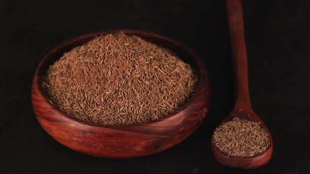 Carvi seeds on wooden table,caraway healthy spice in wooden spoon,jeera or Cumin seeds on black background,